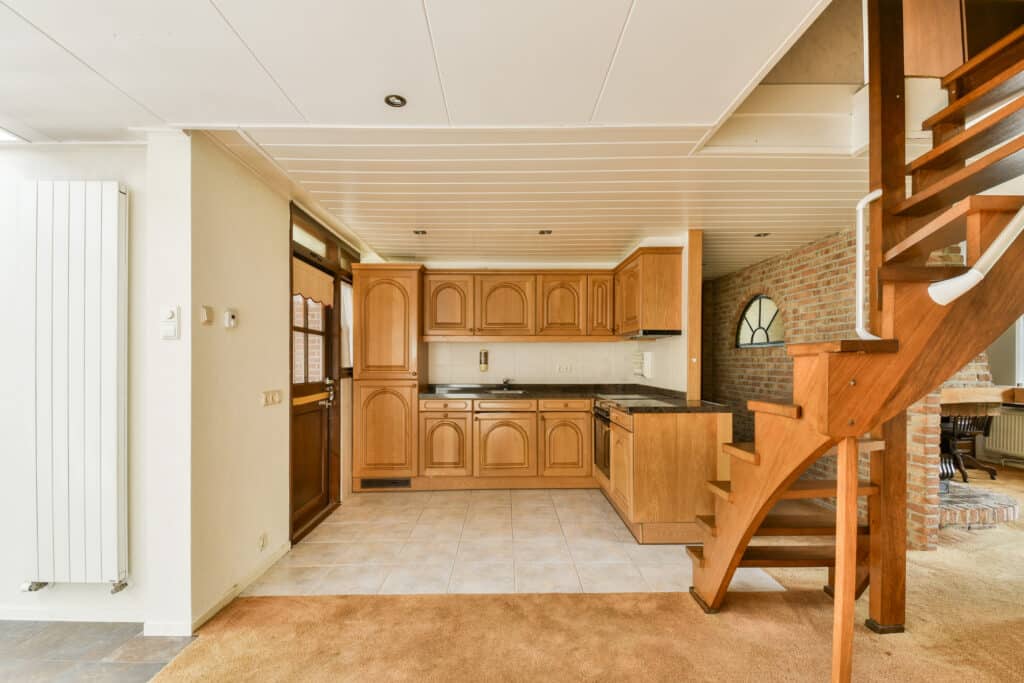 Warm wooden basement kitchen with staircase.
