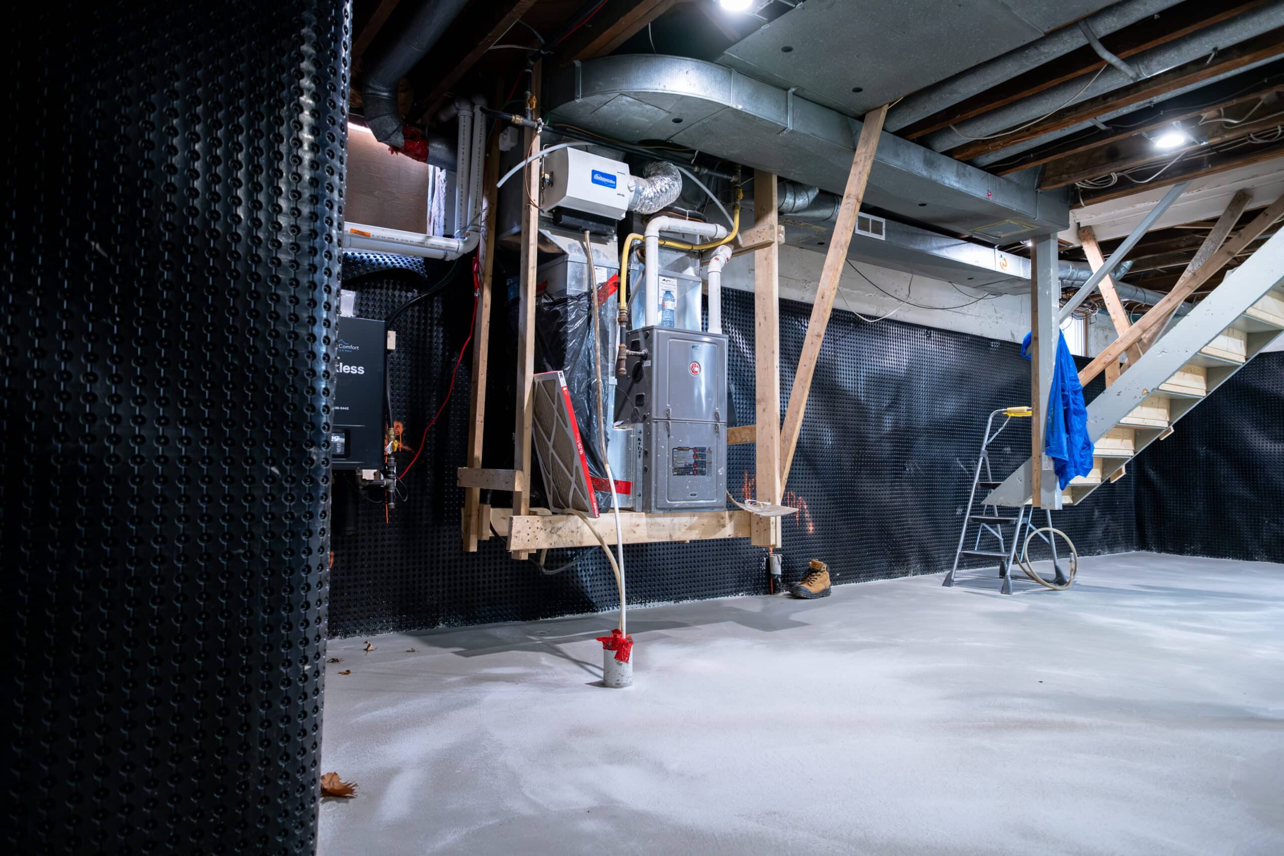 basement-underpinning-toronto-subsidy-program-willfix Lowered basement after underpinning with new concrete floor, dimple mat waterproofing on walls and furnace temporarily elevated on wooden platform
