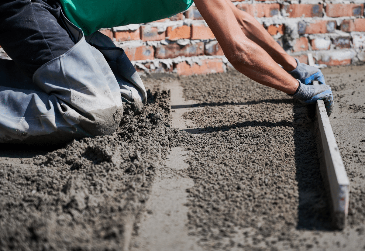 Worker leveling fresh concrete surface
